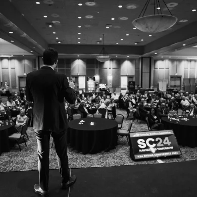 Josh Fletcher performing on stage at the Kentucky Bankers Association SC24 conference ballroom